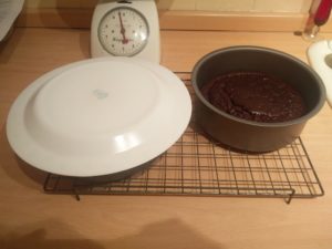 One of the cakes with a plate on ready to tip over