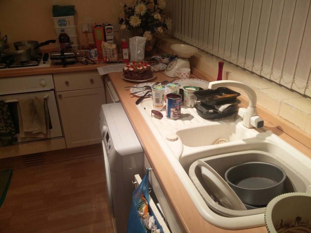 A view of a very messy kitchen full of items with remnants of food on them