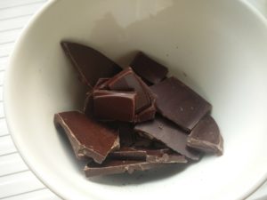 Broken pieces of dark chocolate in a bowl