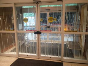 The entrance door at the hotel with a variety of warning stickers on it