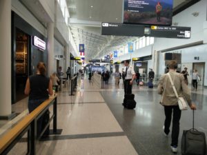 Looking down the terminal building at Washington Dulles Airport, with a number of gates, shops and passengers