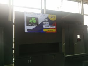 A screen at the gate showing our flights details