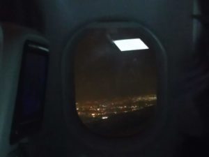 A view out of the plane window over Dublin at night time, with lots of lights showing