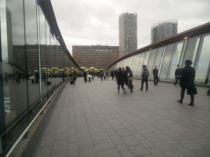 The bridge over the train lines, showing few people on it
